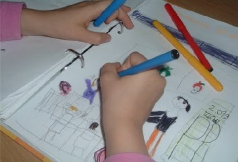 Una niña colorea una de sus figuras.