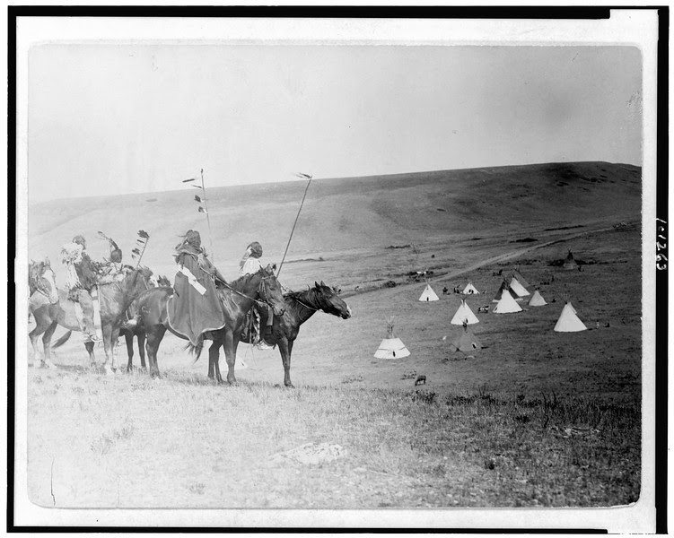 Description of  Title: War party's farewell--Atsina.  <br />Date Created/Published: 1908.  <br />Summary: Four Atsina Indians on horseback overlooking tepees in valley beyond.  <br />Photograph by Edward S. Curtis, Curtis (Edward S.) Collection, Library of Congress Prints and Photographs Division Washington, D.C.