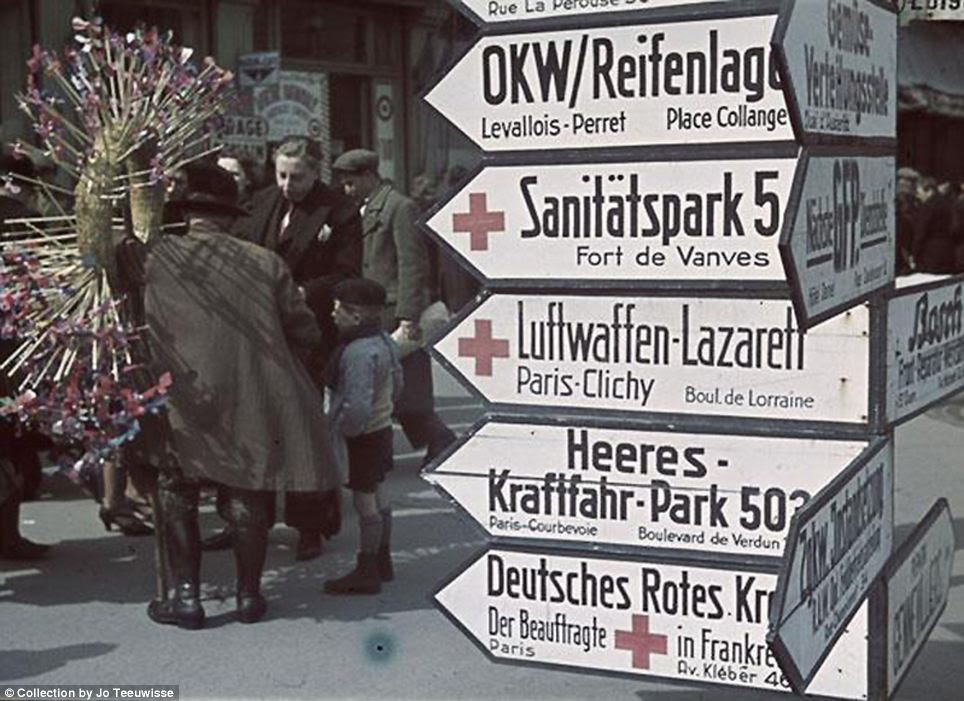 Letting them know who's boss: Street signs advertise locations of German facilities in Paris, with their French names written in smaller text beneath