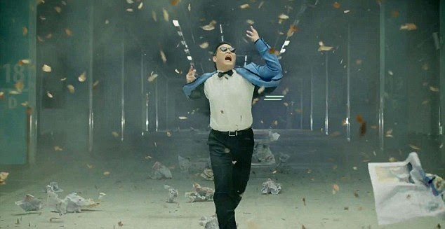 Dressing up: Psy tries on a range of brightly coloured tuxedos in the hit video