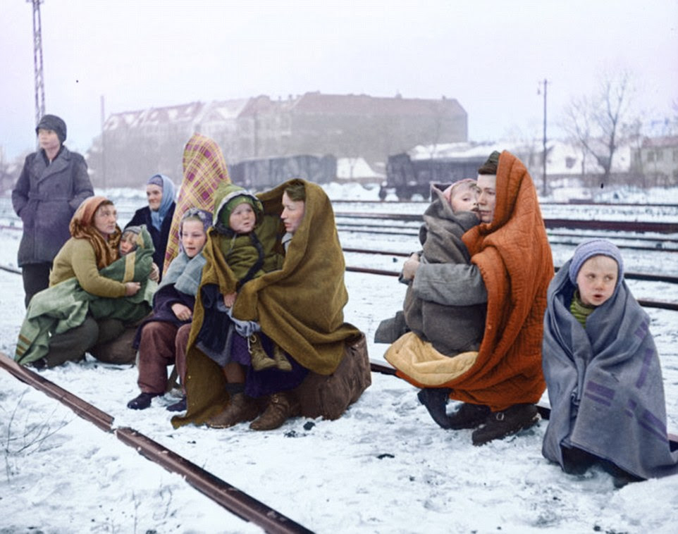 Refugees: This pictures shows Germans who were expelled from Poland and walked from Lodz, Poland, to Berlin on December 14, 1945. Huddling in blankets, they are waiting by a railway track hoping to be picked up by a British army train