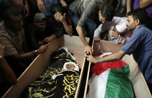 Palestinians mourn over the bodies of Mo