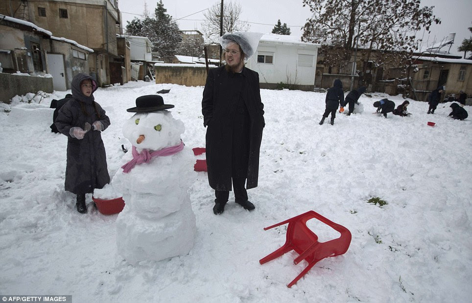 Orthodox Jews enjoy the wintry weather by building snowmen in the Mea Shearim neighborhood of Jerusalem 
