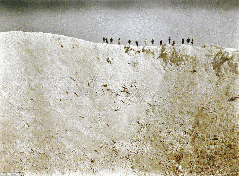This dramatic photograph shows soldiers standing on a ridge above a crater 45m deep created by mines placed by British forces underneath German positions near Messines in West Flanders on 7 June 1917. Some 10,000 soldiers died in the bla