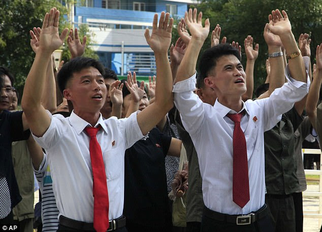 North Koreans are pictured reacting with joy to the news of the latest nuclear test