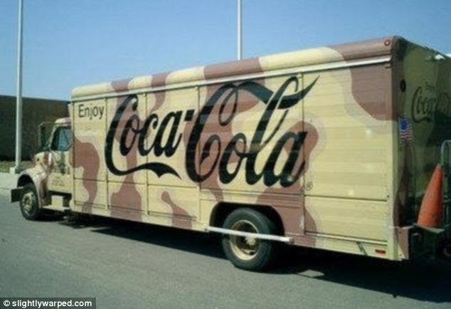 Disguise: This photo shows a Coca-Cola lorry hidden by army camouflage