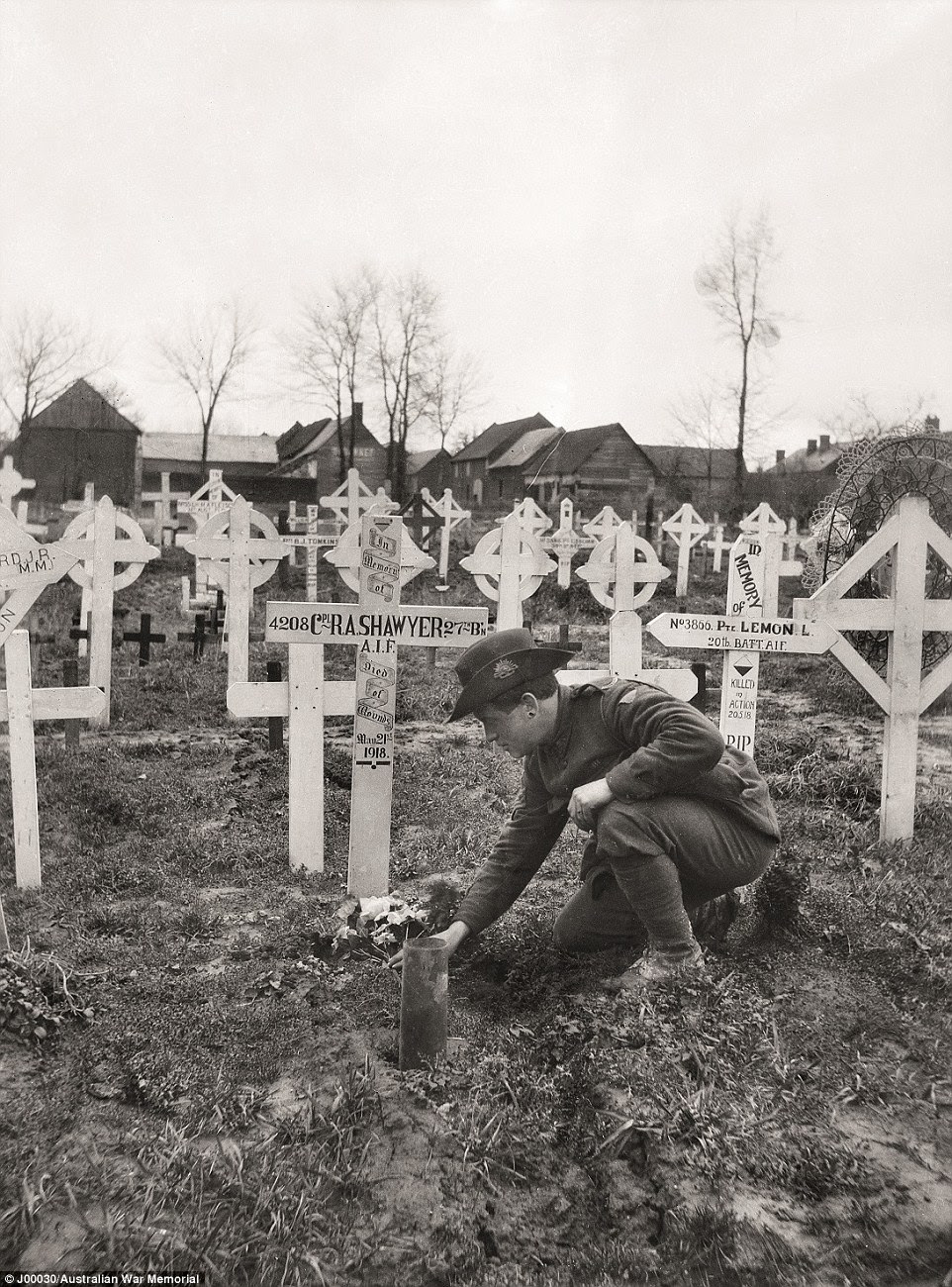 A member of the 27th Battalion attends the grave of a comrade at Franvillers, Somme, a few months after the war