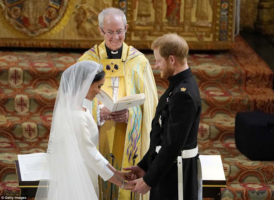 O arcebispo de Canterbury sorri enquanto o prÃncipe Harry e Meghan Markle estão no altar da capela de São Jorge
