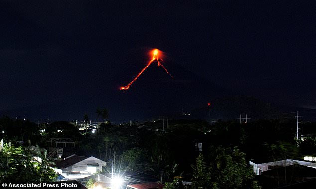 Lava cascades down the slopes of Mayon volcano as seen from Legazpi city, Albay province, around 340 kilometers (210 miles) southeast of Manila, Philippines, Monday, Jan. 15, 2018. More than 9,000 people have evacuated the area around the Philippines' most active volcano as lava flowed down its crater Monday in a gentle eruption that scientists warned could turn explosive. (AP Photo/Earl Recamunda)