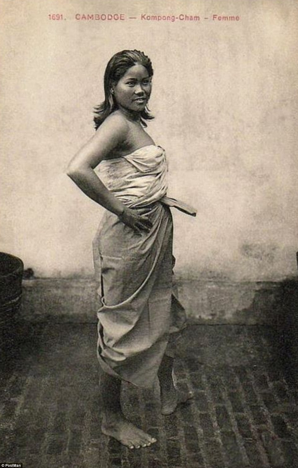 Worldwide style: A Cambodian woman pictured circa 1906 poses barefoot with an ill-fitting skirt and strapless top