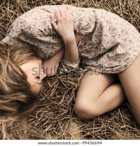 beautiful girl lying in the dry grass