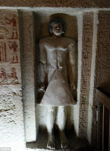 View of a standing statue of Iasen, wearing a stiff triangular kilt, inside The Tomb of Iasen