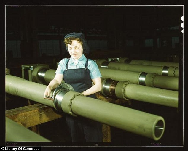 Milwaukee work: Gist inspector Mary Betchner looks at one of the 25 cutters for burrs before inserting it in the inside of a 105mm howitzer at the Wisconsin plant of the Chain Belt Co (Howard R. Hollem, February 1943)