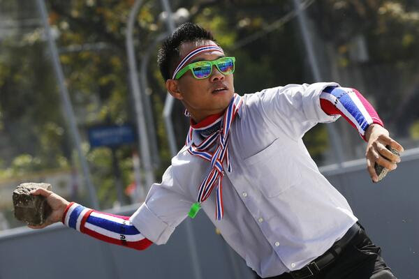 Manifestante lancia una pietra contro la polizia che difende il Palazzo del Governo thailandia manifestante Thailandia: scontro frontale contro la democrazia