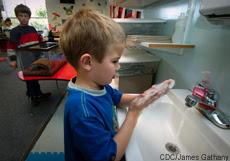 Photograph of a young boy washing his hands Photograph of a young boy washing his hands