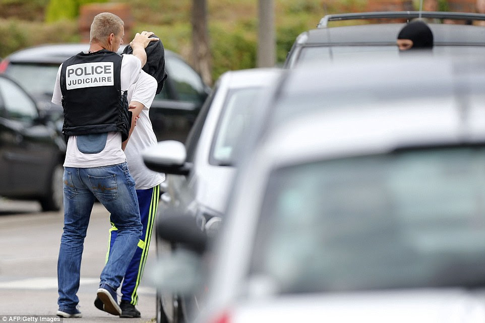 Apreensão: O homem foi retratado sendo empacotado em um carro da polícia depois de um ataque a uma casa na cidade de Saint-Etienne-du-Rouvray