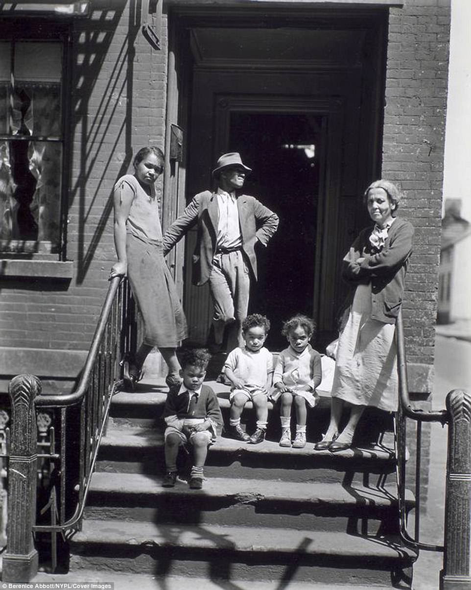 A family on a stoop at Jay Street, No. 115, Brooklyn - many of New York's  stoops - a small staircase ending in a platform and leading to the entrance of an apartment building or other building - have disappeared. Yet those that remain are still a beloved architectural feature of the city