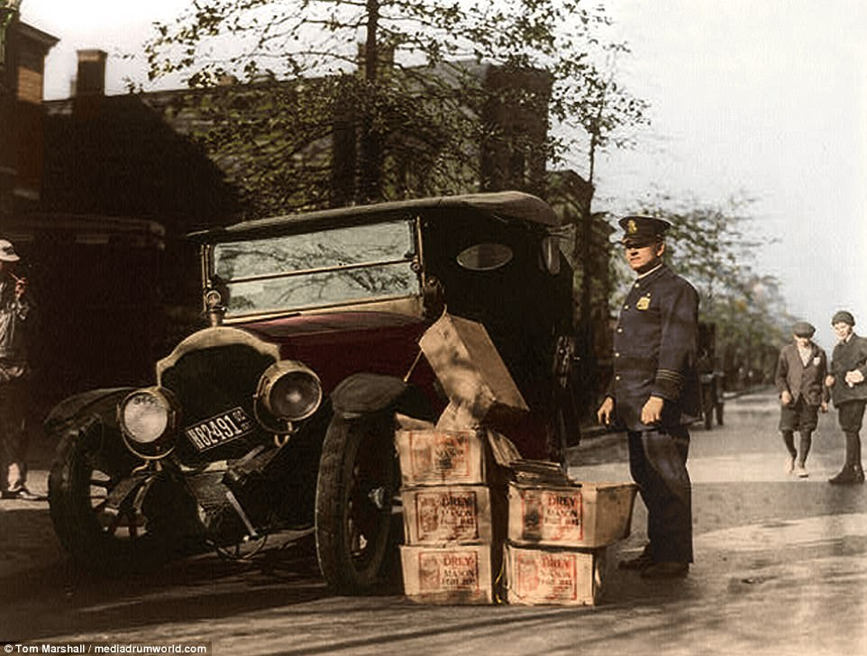 Policeman and Prohibition agents often pulled over suspisious looking vehicles they believed to be carriying illegal cases of alchol. Pictured above, one policeman stands alongside a wrecked car and cases of moonshine, that were likely confiscated