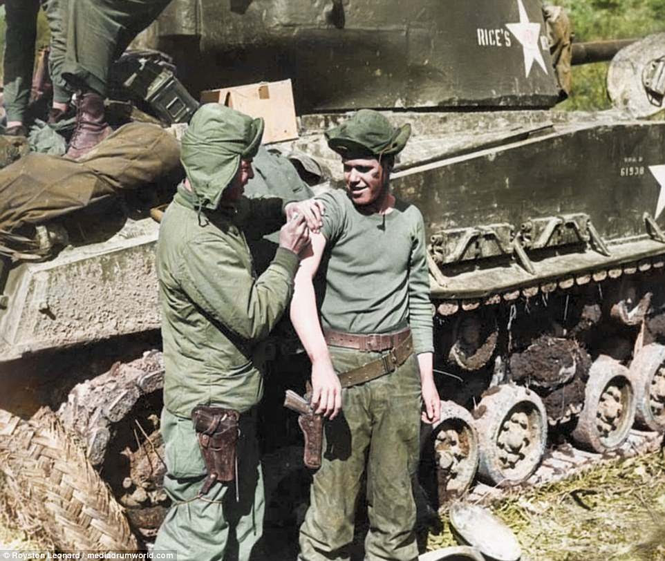 The fighting ended on 27 July 1953, when an armistice was signed. The agreement created the Korean Demilitarized Zone to separate North and South Korea, and allowed the return of prisoners. Pictured above, a military member tends to his comrade's shoulder next to a large tanker