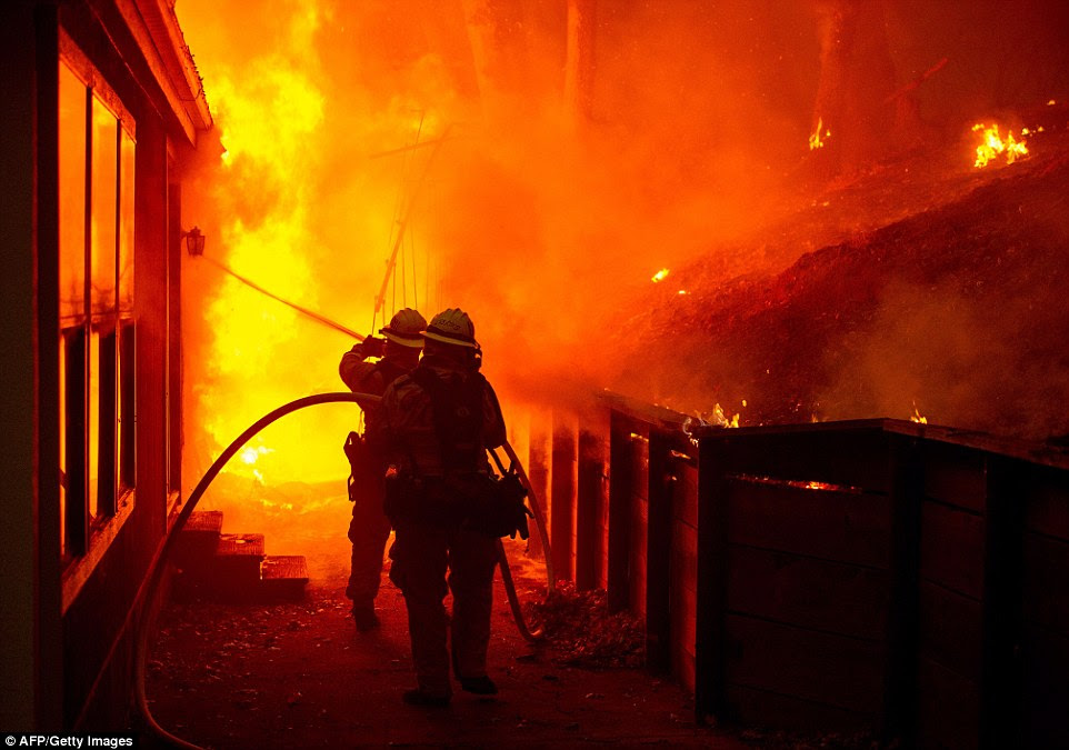Inferno: Firefighters attempt to put it out a house engulfed in flames in Seigler Springs, California late on Sunday evening