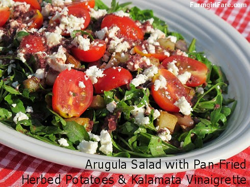 Arugula salad with pan-fried herbed potatoes, cherry tomatoes, feta cheese, and kalamata olive vinaigrette - FarmgirlFare.com