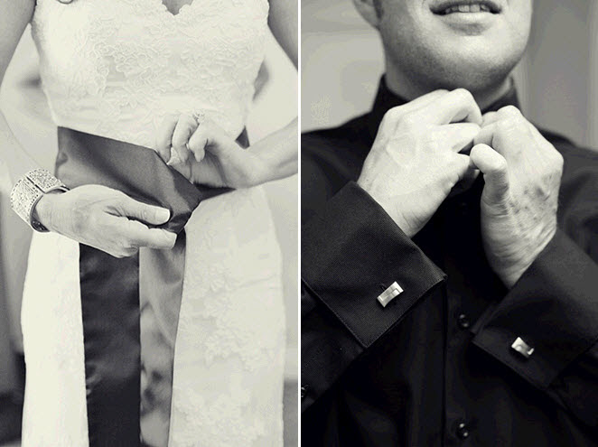 Bride ties the black sash on her ivory lace wedding dress groom buttons up