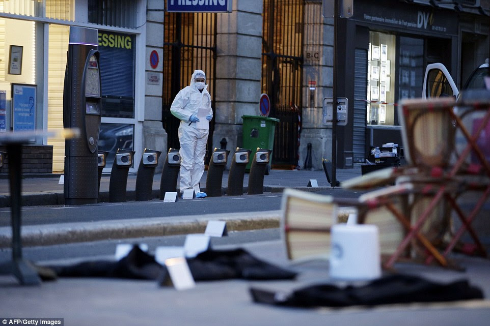 A forensic scientist inspects the scene outside of the Cafe Bonne Biere on Rue du Faubourg du Temple in Paris on Saturday