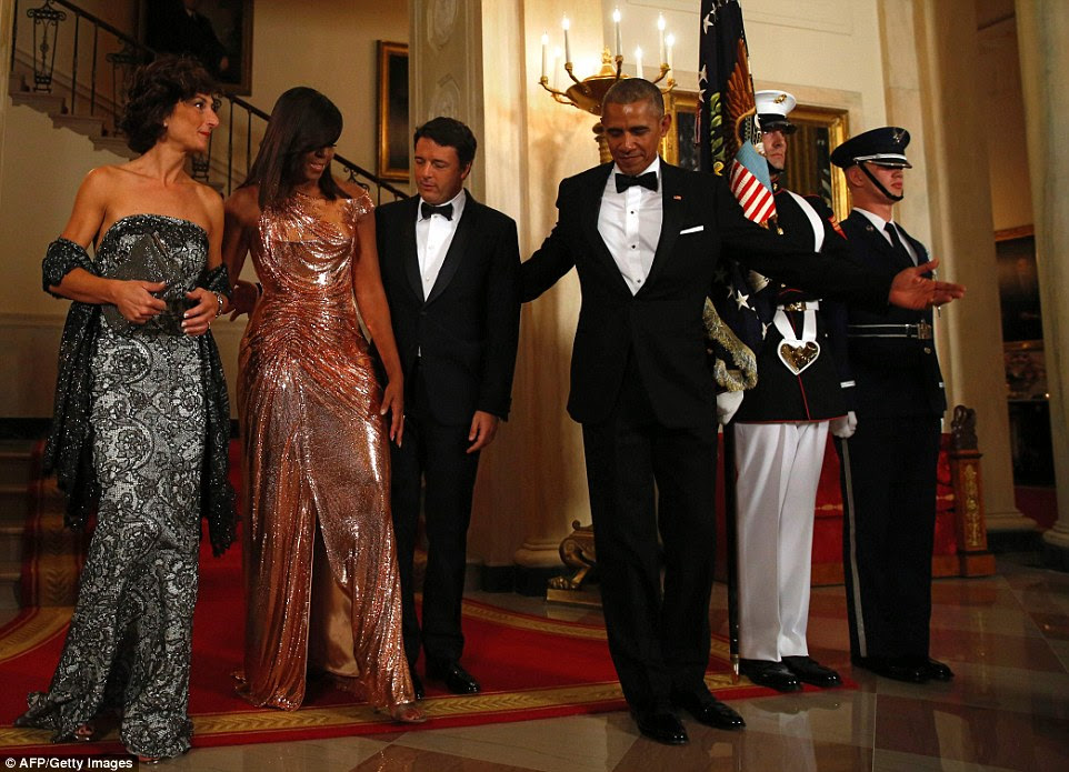 Easy does it: Italy's PM helps Michelle navigate off the carpet and onto the marble floor with a guiding hand on the back