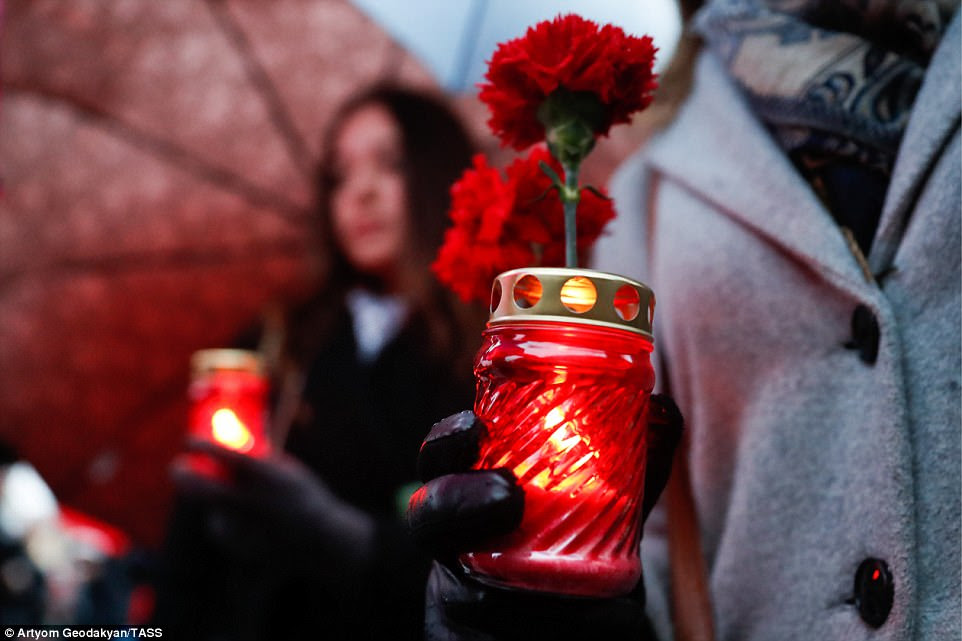 People lighting candles at the Leningrad Hero City memorial by the Kremlin Wall in memory of the St Petersburg metro explosion victims