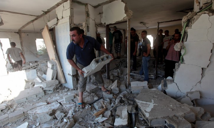 Palestinians inspect the demolished home of Ziad Awad from the West Bank village of Idhna, south of the West Bank city of Hebron, 02 July 2014. EPA/ABED AL HASHLAMOUN