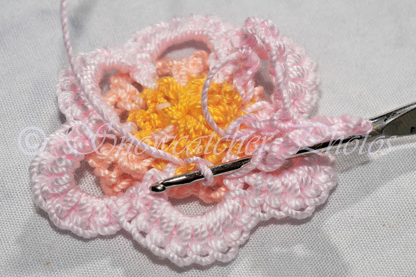 1 double crochet around post of Round 1 double crochet at bottom middle of next single crochet petal 1 double crochet around post of Round 1 double crochet at bottom middle of next single crochet petal