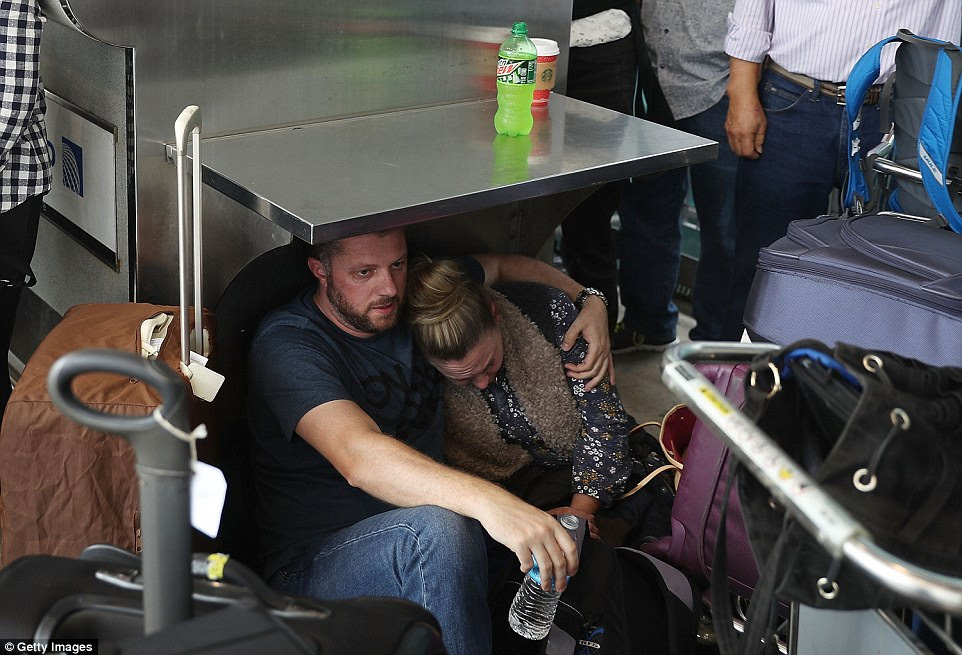 People wait at the Fort Lauderdale-Hollywood International airport after a shooting took place near the baggage claim