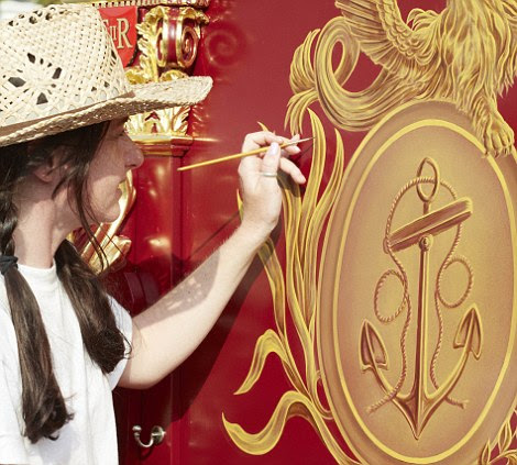 Finishing touches: Artist Catherine Quinn carefully paints a golden ¿fouled¿ anchor, which is the official insignia of the Lord High Admiral