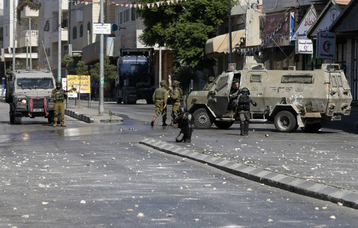 Israeli soldiers and border policemen take position during clashes with Palestinians in the West Bank city of Hebron September 23, 2014. REUTERS/Ammar Awad