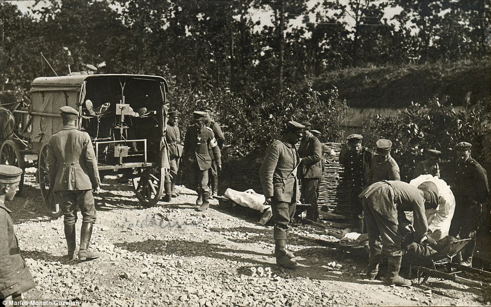 A solider is seen to by medical staff as he lies on a stretcher (bottom right) while two of his comrades are already loaded into the back of a cart