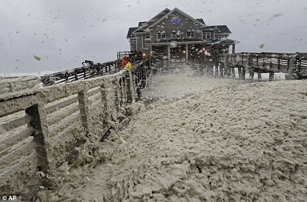 High winds blow sea foam onto Jeanette's Pier in Nags Head, North Carolina today as wind and rain from Hurricane Sandy move into the area