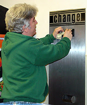 Photo: Mike inserts a dollar into a slot machine.