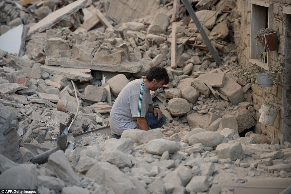 Grief: Uma soluços italiana nos escombros fora de sua casa danificada como as pessoas diziam vilas e cidades foram destruídas pelo terremoto de magnitude 6,2