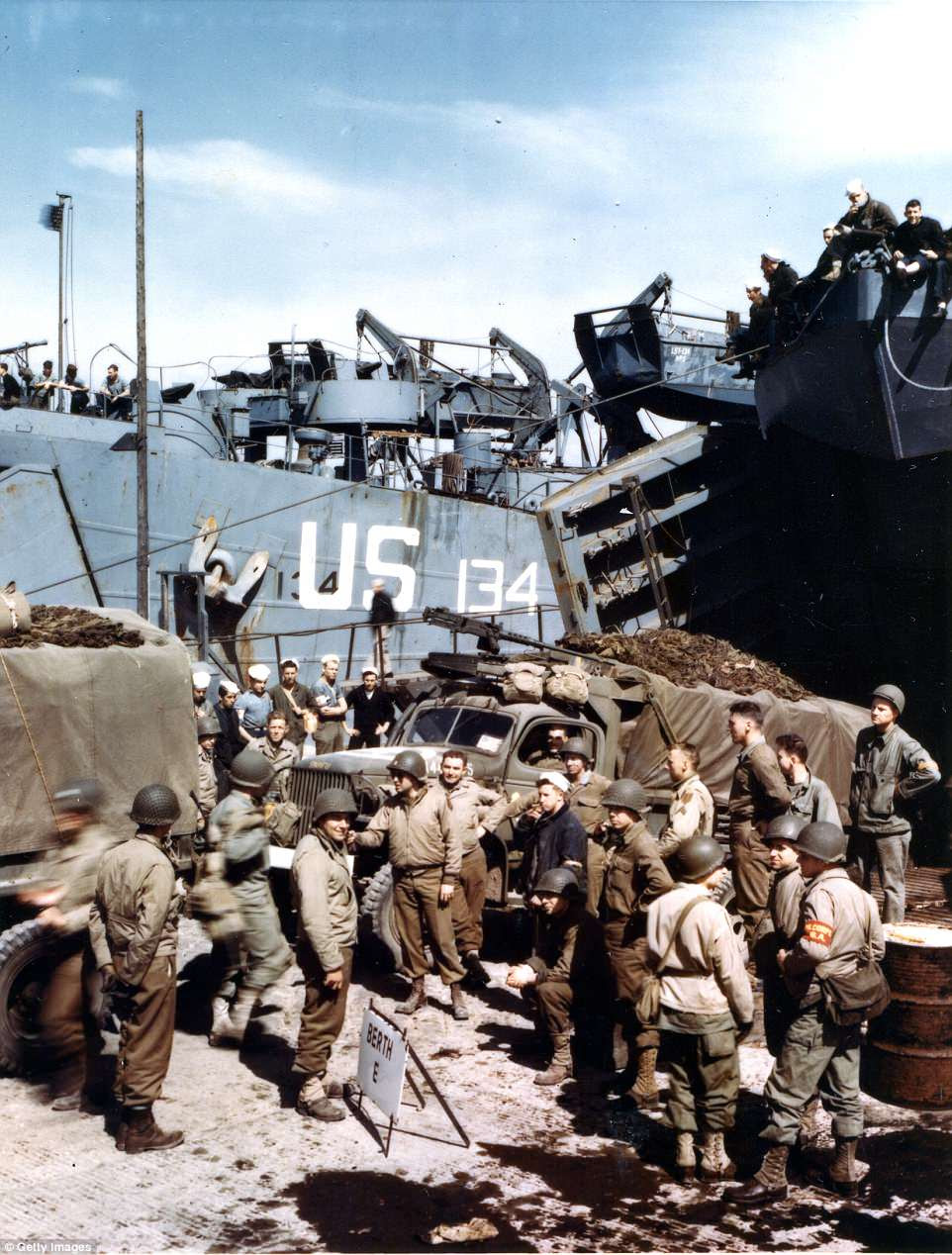 View of American trucks as they are loaded onto an unidentified LST (Landing Ship, Tank), as a number of soldiers stand by in Weymouth, England, milling around with their last days before shipping out to the fight