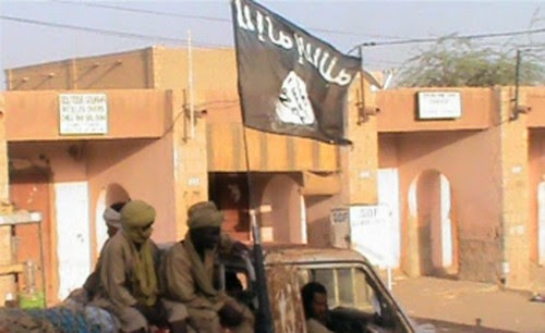 Photograph of a truck carrying members of the Islamist Ansar Dine of northern Mali. There is a black flag symbolizing there Islamic orientation flying overhead on the vehicle. by Pan-African News Wire File Photos