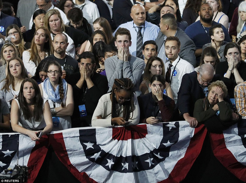 apoiantes de Hillary Clinton segurar suas mãos à boca como eles reagem a resultados eleitorais durante a noite comício eleitoral do candidato democrata