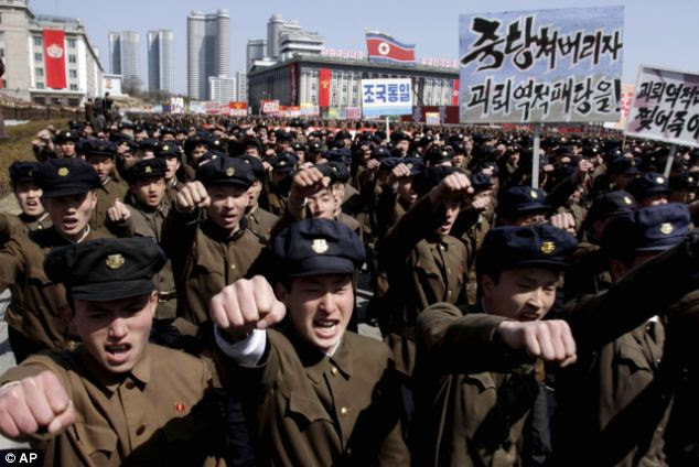 University students punch the air as they march through Kim Il Sung Square