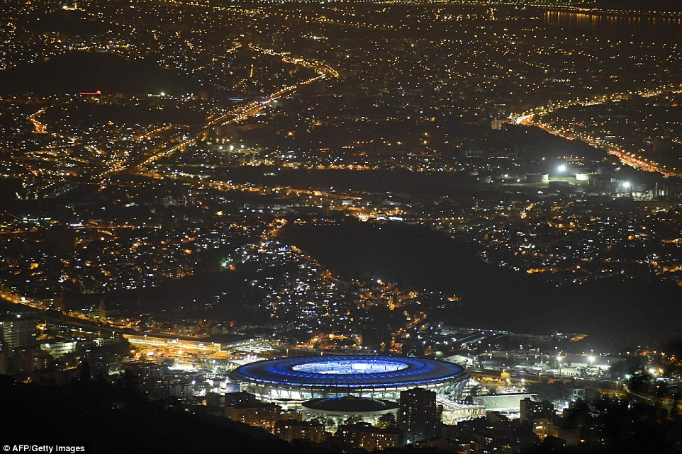 Dezenas de milhares de fãs de streaming para o Estádio do Maracanã para a cerimônia eram guardados por quase tantos policiais e soldados fortemente armados (foto é o estádio visto iluminada à noite para a cerimônia)