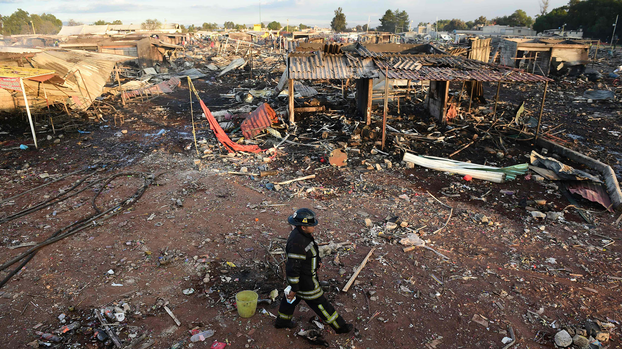 Firefighters work amid the debris