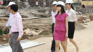 Tô Linh Hương, người mặc váy hồng, đi thăm công trường