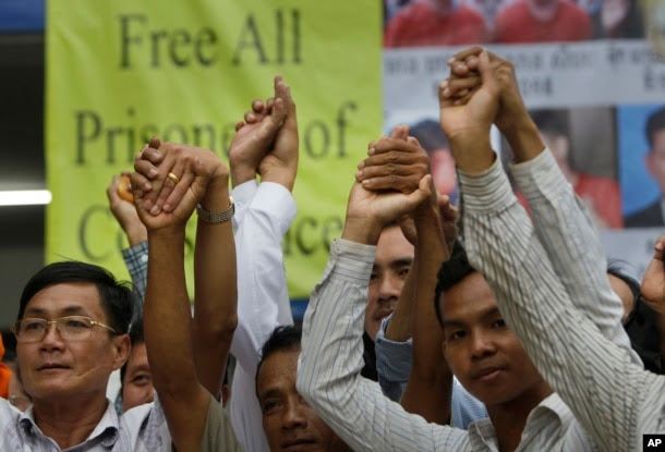 Members of the opposition Cambodia National Rescue Party raise joined hands for photographs at their party headquarters in Phnom Penh, May 27, 2016.