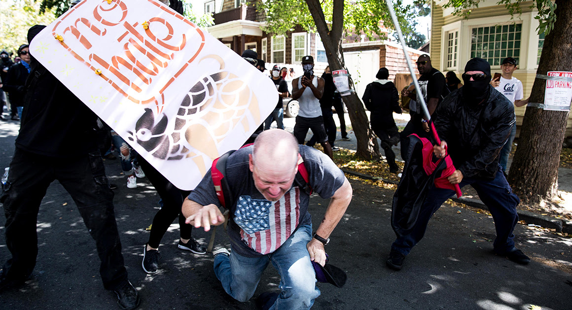 Protesters in black, associated with Antifa, beat a man with a pole and shield during a "No-To-Marxism" rally Aug. 27 in Berkeley, California.