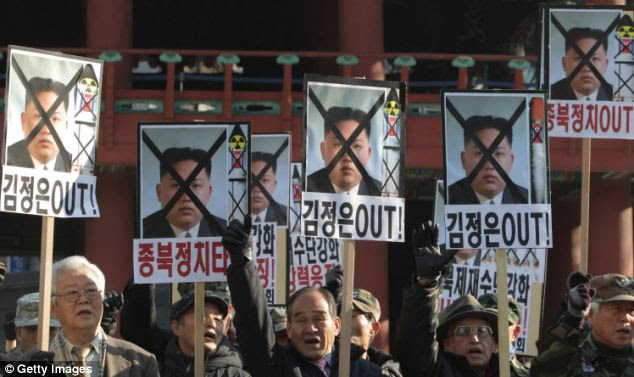 Demonstrations: Protestors hold up signs with new leader Kim Jong Un's face crossed out 