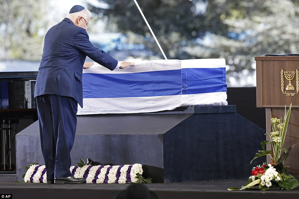 Colocando as mãos: presidente de Israel, Reuven Rivlin paga seus respeitos para o caixão coberto pela bandeira de Shimon Peres