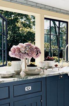 Open windows, fresh air and lavender hydrangeas complement blue-gray kitchen cabinets in Ralph Lauren Paint Rue Royale